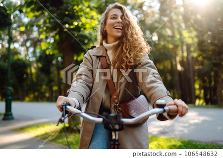 Beautiful woman riding bicycle in park. Lifestyle. Relax, nature concept. Spring time. Beautiful woman riding bicycle in park. Lifestyle. Relax, nature concept. Spring time. 106548632