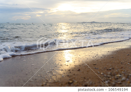Seawater soft wave crashing on sandy beach seaside in summer on sunset time. summer vacation activity background concept.. 106549194
