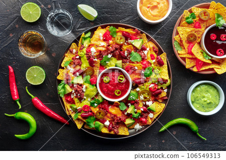 Loaded nachos. Mexican nacho chips with beef, overhead flat lay shot 106549313