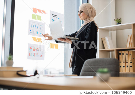 Expert analyzing report with charts using laptop at work 106549400