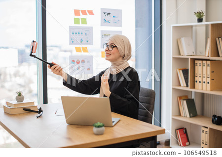 Adult with monopod chatting online via cell phone at work Adult with monopod chatting online via cell phone at work 106549518