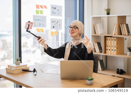Muslim female with mobile on stick filming video in office 106549519