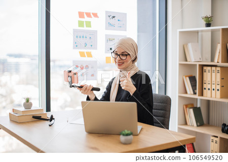 Muslim female with mobile on stick filming video in office 106549520