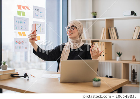 Woman talking online via internet app on phone in workplace 106549835