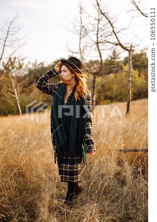Stylish woman enjoying autumn weather in the park. Fashion, style concept. People, lifestyle. 106550111