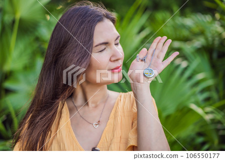 pregnant woman after 40 demonstrating the use of an aroma pendant, combining style and aromatherapy during her pregnancy journey 106550177