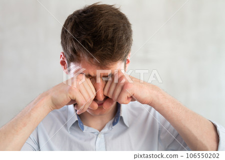 Man scretching itchy eyes on gray background 106550202