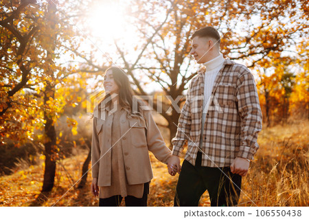 Couple having fun walking, hugging on autumn park at sunset. People, lifestyle, relaxation concept. 106550438