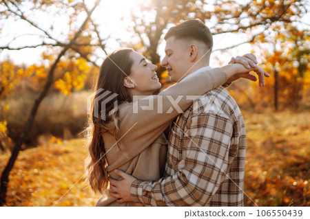 Couple having fun walking, hugging on autumn park at sunset. People, lifestyle, relaxation concept. 106550439