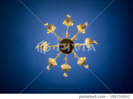 golden chandelier against a blue ceiling golden chandelier against a blue ceiling 106550842