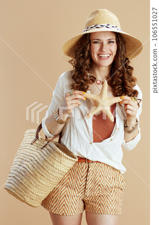 happy elegant woman in blouse and shorts on beige happy elegant woman in blouse and shorts on beige 106551027