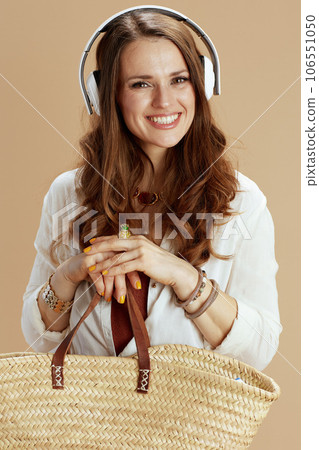happy stylish woman listening to music on beige happy stylish woman listening to music on beige 106551050