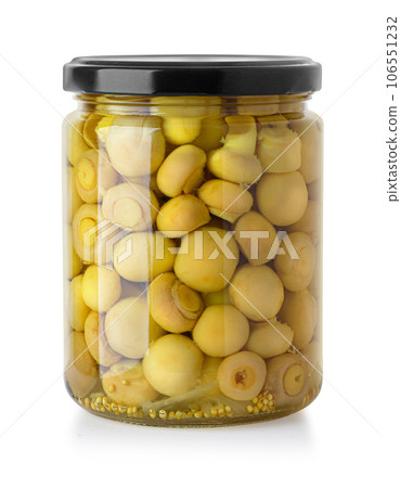 Glass jar with marinated champignons 106551232
