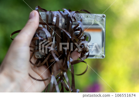 An old audiocassette with tangled tape in my hand 106551674