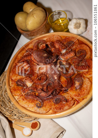 Octopus Typical Spanish dish served with paprika, salt, potatoes and olive oil 106551861