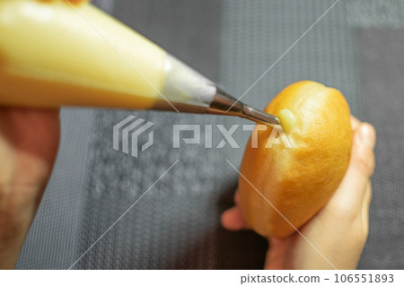 Hands filling Krapfen with Vanilla Cream. Dessert from Germany like donuts dough 106551893