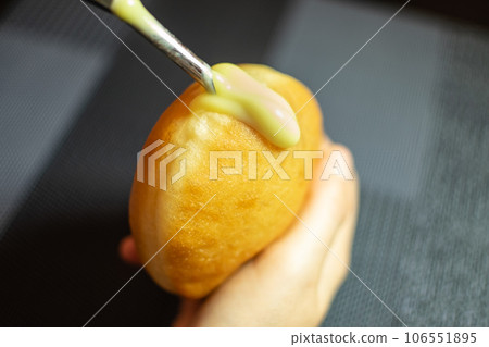 Hand filling Krapfen with Vanilla Cream. Dessert from Germany like donuts dough 106551895