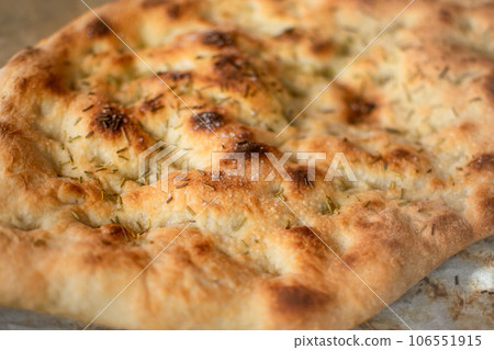Typical Italian Focaccia Bread dough with oil and rosemary baked Typical Italian Focaccia Bread dough with oil and rosemary baked 106551915