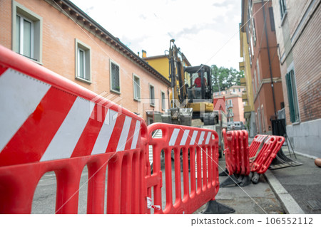 Red barriers marked as safety in construction work with excavator in background Red barriers marked as safety in construction work with excavator in background 106552112