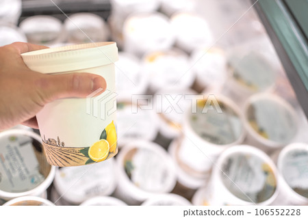 Hand taking Ice Cream stocked on supermarket for selling and ready for consumption 106552228