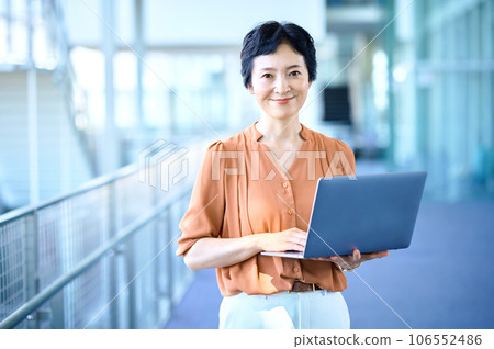 Middle business woman with a laptop with a smile 106552486