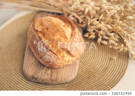 Bakery - golden rustic crispy loaves of bread on a wooden board and a light background. Still life shot from above. Layout with free space to copy. High quality photo 106552495