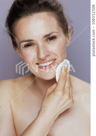 smiling modern woman with cotton pad on blue 106552506