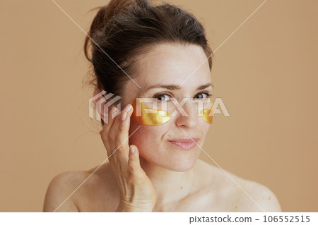 young female with eye patches on beige background young female with eye patches on beige background 106552515