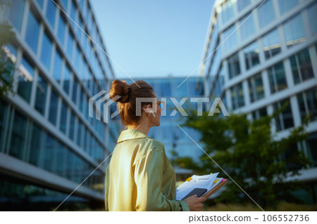 Seen from behind woman worker near business center using phone 106552736