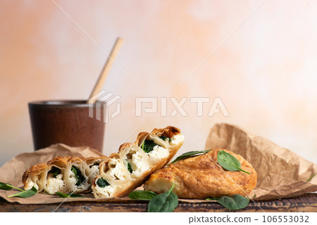 Homemade pies with spinach and cup of coffee Homemade pies with spinach and cup of coffee 106553032