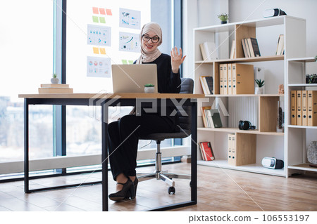 Female manager having online discussion via webcam in office Female manager having online discussion via webcam in office 106553197