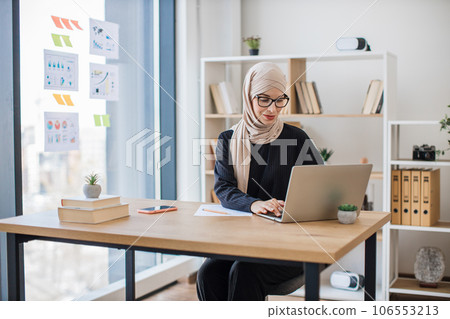 Muslim worker unlocking keyboard of laptop in workplace 106553213