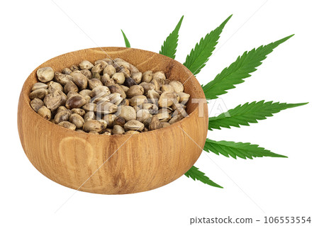 Hemp seeds in wooden bowl isolated on white background with full depth of field Hemp seeds in wooden bowl isolated on white background with full depth of field 106553554