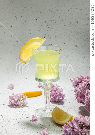 traditional liqueur limoncello with blooming lilac on a light background 106554253