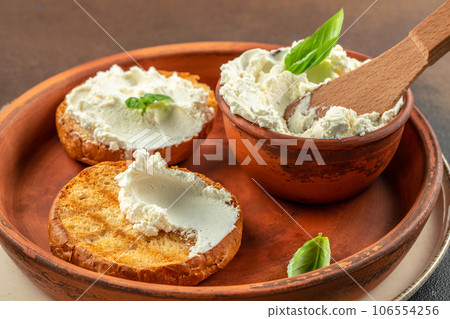 Sandwiches with tasty cream cheese and fresh basil leaves. Food recipe background. Close up 106554256