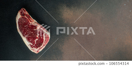 Raw New York steak on a dark background. Long banner format. top view 106554314