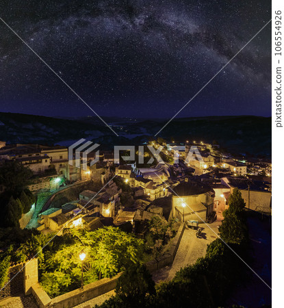 Night old medieval Stilo famos Calabria village view with Milky Way galaxy stars above , southern Italy. Night old medieval Stilo famos Calabria village view with Milky Way galaxy stars above , southern Italy. 106554926
