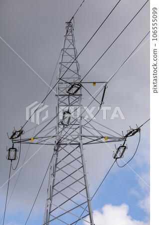 Metal high voltage pole against a background of gray dark clouds. 106555099