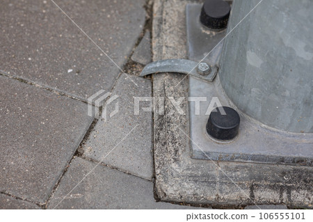 A metal lamp post attached to a concrete base. A metal lamp post attached to a concrete base. 106555101