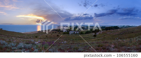 Sunlight path on sea water surface and evening town on horizon. 106555160