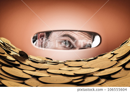 Astonished man looks inside the piggy bank with a magnifying 106555604