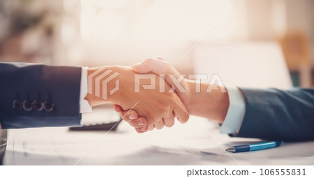 Businessmen shaking hands each other in the office. 106555831