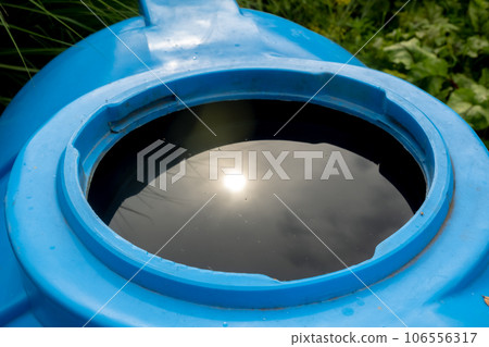 water collection tank under a roof with a drain. Rain water harvesting 106556317