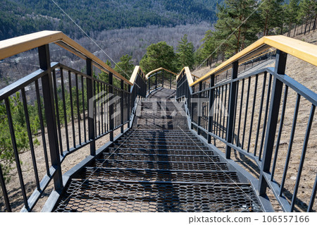 Metal stairs with wooden railings on the mountain. Metal stairs with wooden railings on the mountain. 106557166