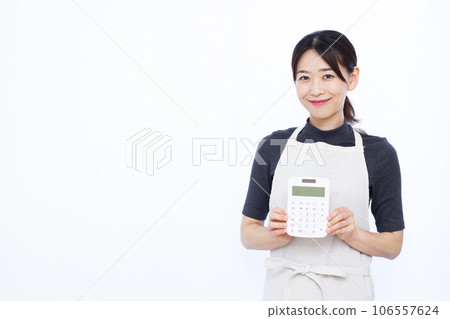 一位 30 多歲的家庭主婦在白色背景前拿著計算器 106557624