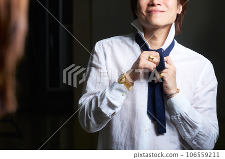 喜歡配飾的男人的手在鏡子前準備男士珠寶時尚形象 喜歡配飾的男人的手在鏡子前準備男士珠寶時尚形象 106559211
