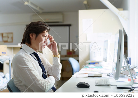Business person thinking while looking at a computer screen Business person thinking while looking at a computer screen 106559222