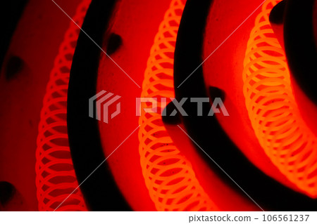 復古電爐三腳架部分的特寫照片，電熱絲（捲繞鎳鉻合金絲）加熱至鮮紅色 106561237