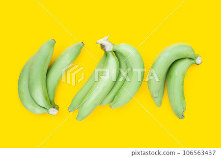 Green banana on yellow background Green banana on yellow background 106563437