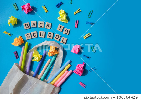 BACK TO SCHOOL message inscription text on wooden blocks on creative colorful blue background with stationery supplies around. Copy space Educational greeting announcement for students and teacher BACK TO SCHOOL message inscription text on wooden blocks on creative colorful blue background with stationery supplies around. Copy space Educational greeting announcement for students and teacher 106564429